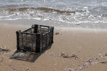 Black plastic crate washed up on a beach in Cyprus