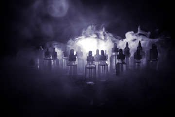 Vape concept. Smoke clouds and vape liquid bottles on dark background. Light effects. Useful as background or electronic cigarette advertisement.