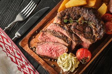 Juicy steak with fragrant butter. Sliced Ribeye Steak with Potatoes, Onions and Baked Cherry Tomatoes