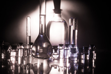 Obraz na płótnie Canvas Pharmacy and chemistry theme. Test glass flask with solution in research laboratory. Science and medical background. Laboratory test tubes on dark toned background