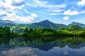 Fototapeta na wymiar Idyllic panorama of picturesque mountains and blue sky reflected in the lake (mixed)