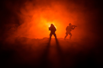 Fototapeta na wymiar Military soldier silhouette with gun. War Concept. Military silhouettes fighting scene on war fog sky background, World War Soldier Silhouette Below Cloudy Skyline At night.