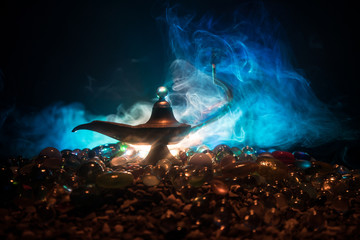 Antique Aladdin arabian nights genie style oil lamp with soft light white smoke, Dark background.