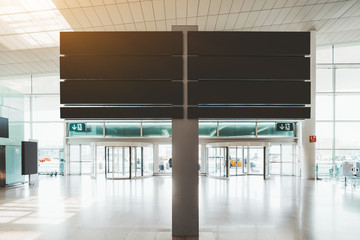 An empty black mockup of a route pointer in a modern airport terminal next to the entrance; blank...