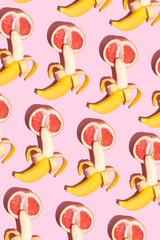 grapefruit and a banana on a pink background