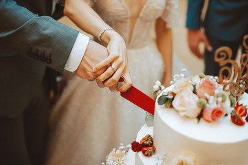 Photo of happy couple bride and groom cutting a wedding cake
