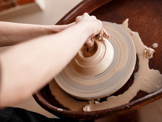 Fototapeta premium Hands sculpt new utensil on a pottery wheel