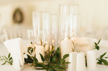 Photo of wedding candles decoration with leaves and glass