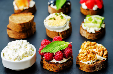 Ricotta and crostini appetizers with fillings on a black background