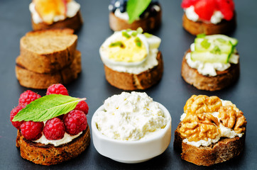 Ricotta and crostini appetizers with fillings on a black background