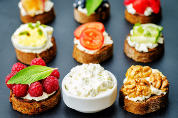 Ricotta and crostini appetizers with fillings on a black background