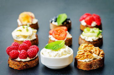 Ricotta and crostini appetizers with fillings on a black background.