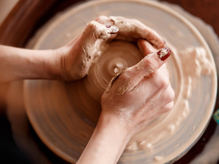 Hands sculpt new utensil on a pottery wheel
