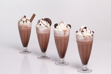 Hot chocolate with whipped cream in mugs isolated on white