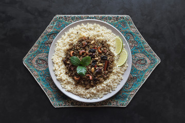 Moroccan spiced mince with couscous on a black. 
