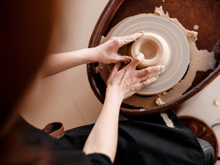 Fototapeta premium Hands sculpt new utensil on a pottery wheel