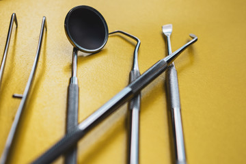 Close-up Dental Instruments on a yellow background. Prevention of oral diseases.