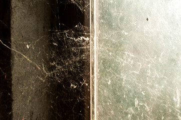 Window of abandoned neglected house with old spider web