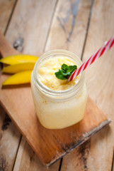 Close-up of mango smoothie in a jar on wooden table