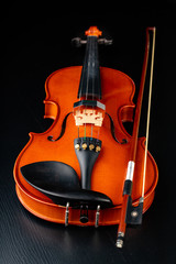 Beautiful new shiny violin on a dark table. Musical string instrument prepared for work.