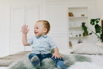 Fototapeta premium Cute little toddler boy waving his hand. Child waving hello or goodbye.