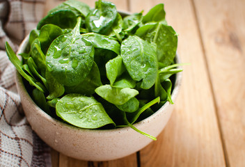 Close-up of baby spinach in a bowl on wooden table