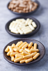 Coenzyme Q10, Alpha Lipoic Acid and Green Tea capsules. Immune system support. Concept for a healthy dietary supplementation. Bright stone background. Close up. 