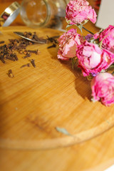 Romantic floral frame background/ Valentines day background/Pink roses on wooden background,dried cloves in a spoon