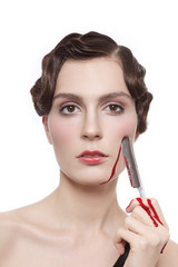 Obraz premium Vintage style portrait of young beautiful woman with fancy prom hairdo and bloody blade in her hand
