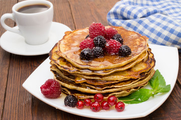 Delicious pancakes with berries and maple syrup. Top