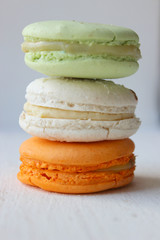 Colorful French or Italian macaroon stack cakes / Macaroon cakes. Assorted macaroon cakes stacked on top of each other on a light background. Copy space. Delicious dessert.
