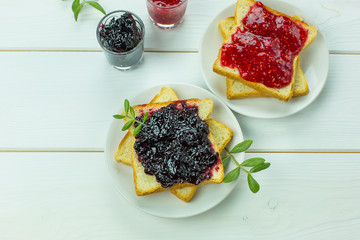 Delicious toast white bread with raspberry and currant jam on wooden table. Food,dessert, homemade food concept