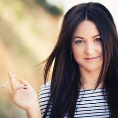 beautiful young woman who smokes a cigarette