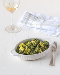 White dish of green saag paneer curry 