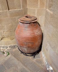 Ancient earthen ware jug near a stone wall