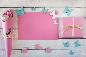 Różowo - białe wiosenne tło z zajączkami, motylkami, kwiatami i pudełkiem przewiązanym wstążką - obrazy, fototapety, plakaty