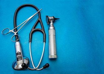 Stethoscope and otoscope on blue background