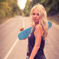 Beautiful young girl hipster with skateboarding in the afternoon © Artem