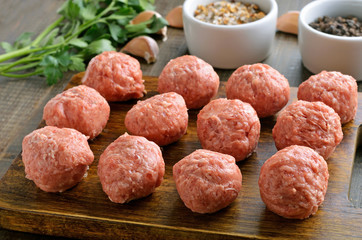 Raw meatballs on a cutting board