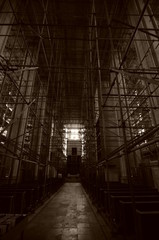 Complicated scaffolding consisting of many poles and struts inside a historic building.