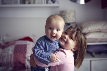 Cute sibling children,Sister holds and hugs baby