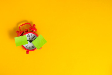 Red retro clock on yellow background. Green sticker for text.
