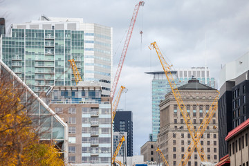 Cranes and building device on a construction site of a skyscraper in downtown Montreal, surrounded...