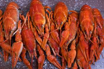 boiled crayfish, salted fish, smoked fish, chips, peanuts, snacks on white plates on a wooden table