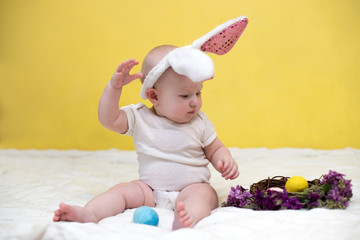 Little newborn baby with bunny ears for easter, Portrait a cute baby dressed in Easter bunny ears with eggs.