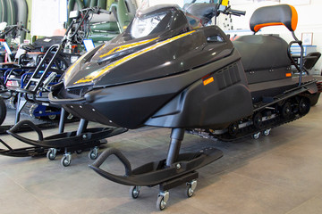 Snowmobile in market. Close-up of row of snowmobiles stand in snow, view from below, skiing.