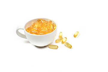 Close up of Gold fish oil in bowl coffee ceramic isolated for good health on white background. Supplementary food. Omega 3. Vitamin E. Capsules salmon fish oil.