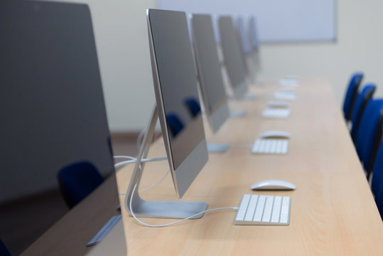 Modern Office With Computers On Desks. Empty Computer Room In College. Interior Of Classroom With Computers. Concept Of Corporate Working Space.