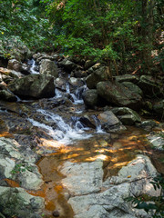 Naklejka na ściany i meble Water flows over the rocks of the waterfall on Koh Phangan. Thailand