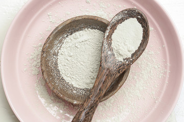Top view of cosmetic clay powder in a wooden bowl 